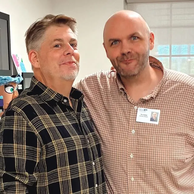 Two smiling men posing together at a Danbury Elderly Services event