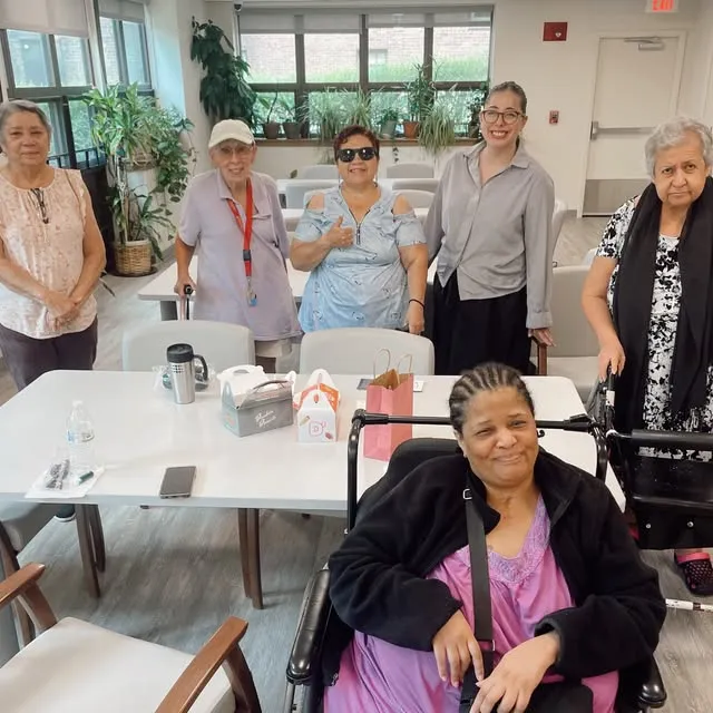 Group of six elderly women smiling together at a community center in Connecticut.